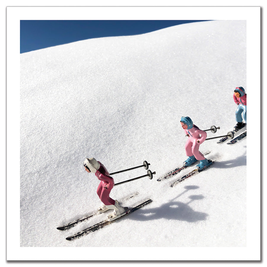 Antique pink toy skiers with blue sky by Hooey Mountain